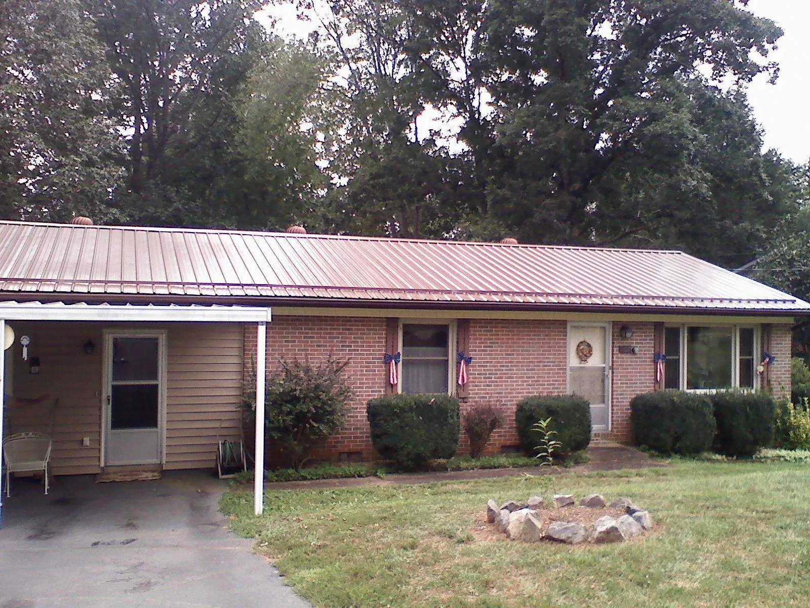 Bronze metal roof and carport on a brick ranch home — Roof Repair work by our crew in Lewes
